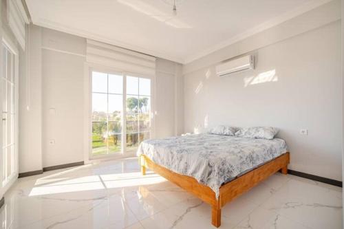 een witte slaapkamer met een bed en een raam bij Likya Karya Villaları in Koycegiz