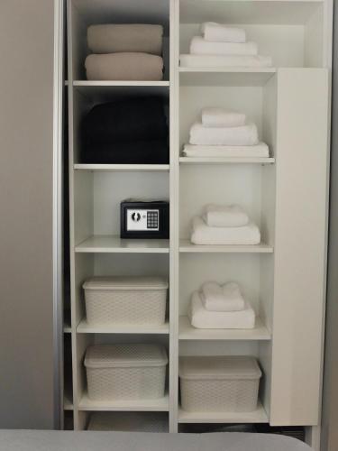 a white closet with white towels and a clock at En el Centro, sobre Av Corrientes, a metros del Obelisco, Teatros y Bares in Buenos Aires