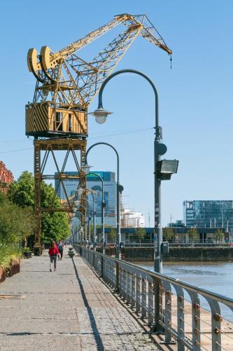 a person walking down a sidewalk next to a crane at En el Centro, sobre Av Corrientes, a metros del Obelisco, Teatros y Bares in Buenos Aires