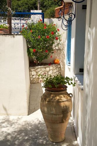 a large vase on the side of a building with flowers at Auntie's Cottage with View, near Agia Efimia in Loukáta