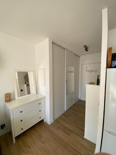 Cette chambre blanche dispose d'une commode et d'un miroir. dans l'établissement Studio cosy proche de la mer, à Nice