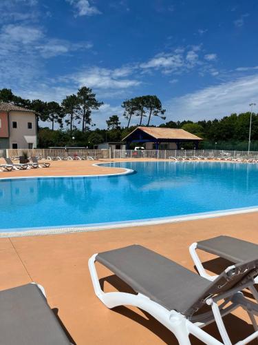 une grande piscine avec des chaises longues et une piscine dans l'établissement Villa 3 chambres 6 personnes résidence de vacances Soustons, à Soustons