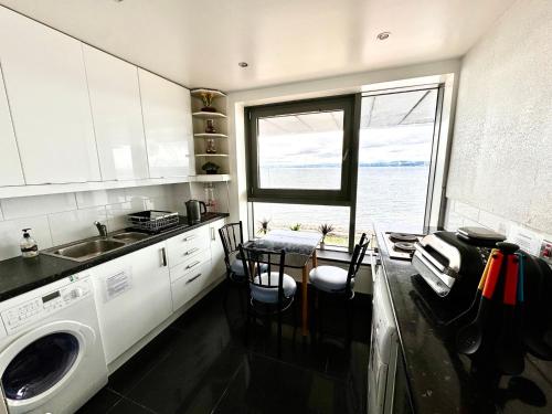 a kitchen with a sink and a washing machine at Ocean Park Apartments - Oceanfront - Free Parking and Fast WiFi in Edinburgh