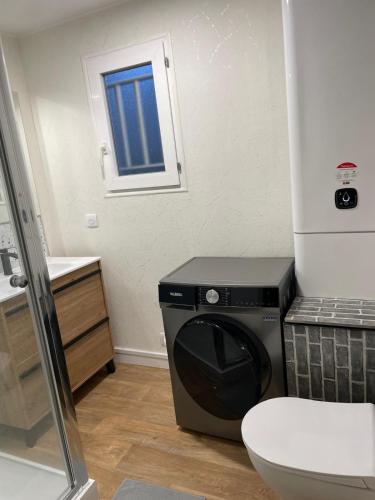une machine à laver dans une salle de bain avec toilettes dans l'établissement Villa 3 chambres 6 personnes résidence de vacances Soustons, à Soustons