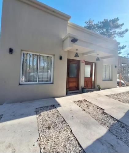a white house with a front door and a driveway at CasaPino Departamentos en Costa del Este in Costa del Este
