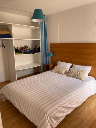 une chambre avec un grand lit blanc avec une lampe verte dans l'établissement Villa 3 chambres 6 personnes résidence de vacances Soustons, à Soustons
