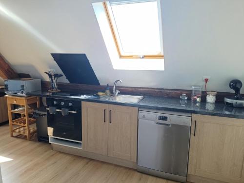 a kitchen with a sink and a stove and a window at hebergement centre ville Chateauneuf-en-thymerais in Châteauneuf-en-Thymerais