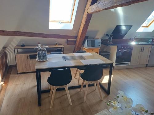 a kitchen with a table and chairs in a room at hebergement centre ville Chateauneuf-en-thymerais in Châteauneuf-en-Thymerais