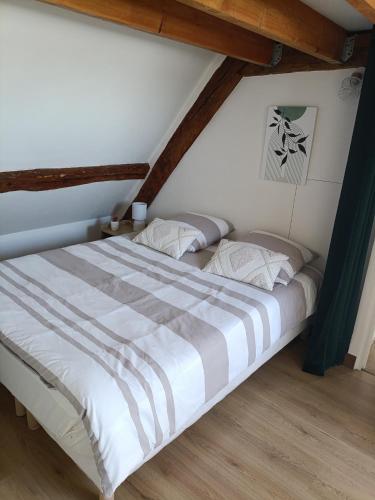 une chambre avec un grand lit dans un grenier dans l'établissement hebergement centre ville Chateauneuf-en-thymerais, à Châteauneuf-en-Thymerais