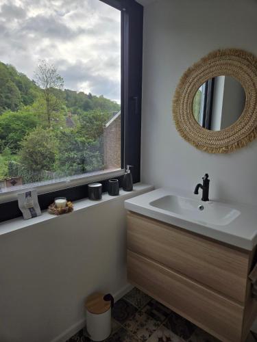 a bathroom with a sink and a mirror and a window at Le Refuge de Franchimont in Theux