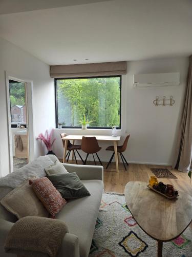a living room with a couch and a table at Le Refuge de Franchimont in Theux