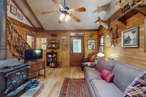 a living room with a couch and a ceiling fan at Andreas Creek Cabin #1 in Boone