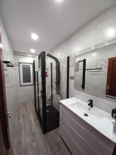 a bathroom with a shower and a white sink at Home from home in Noya