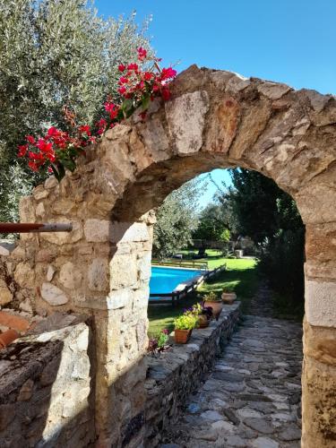 an archway with flowers on a stone wall at Byzantion Hotel in Mystras