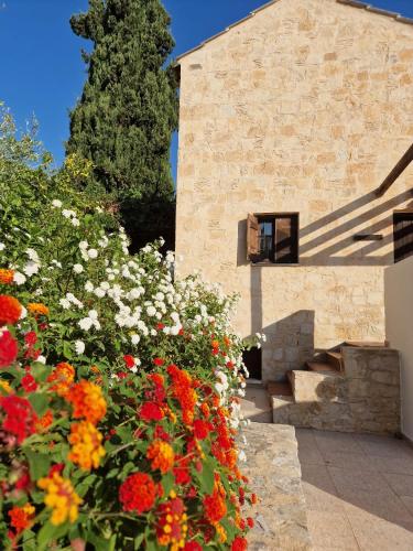 a bunch of flowers in front of a building at Villa Penelope Luxury Retreat with Pool & Timeless Charm in Douliana