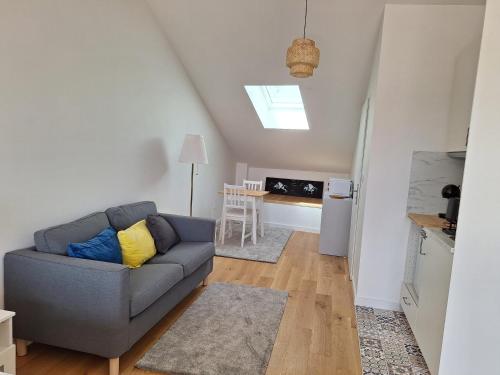 un salon avec un canapé et une cuisine dans l'établissement Studio 1 rénové lit queen size balcon garage, à La Celle-sous-Gouzon