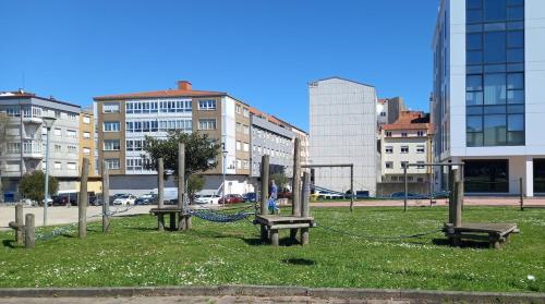 a park with benches in a city with buildings at Home from home in Noya