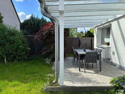 a pergola with a table and chairs on a patio at Wohnzeit-Köln in Cologne
