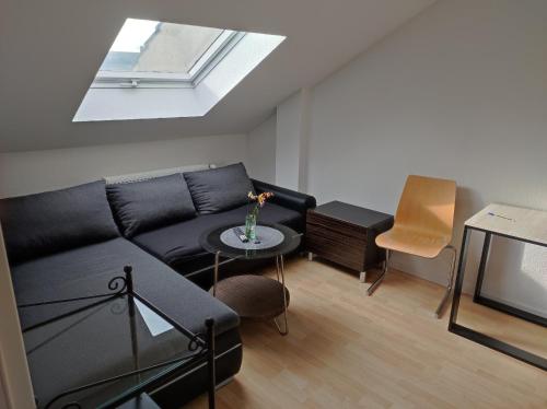 a living room with a black couch and a skylight at du LYS in Mönchengladbach