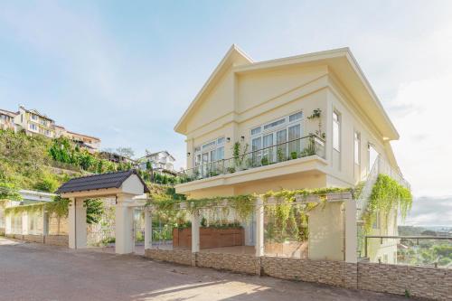 a large yellow house with a fence in front of it at The Gardener by WeDalat in Da Lat