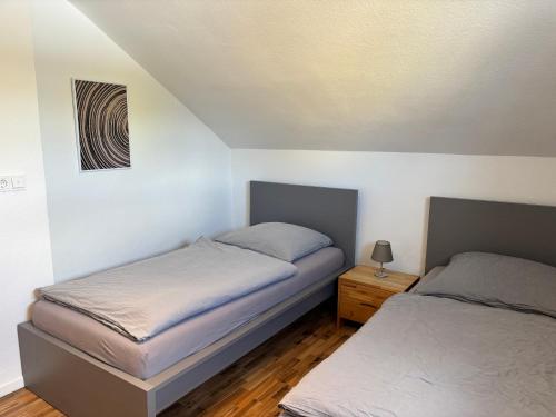 a bedroom with two beds and a night stand at Wohnzeit-Köln in Cologne