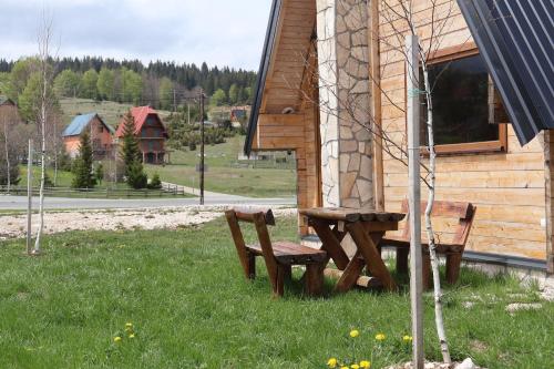 a bench sitting in the grass next to a building at Portes du Soleil - Zabljak in Žabljak