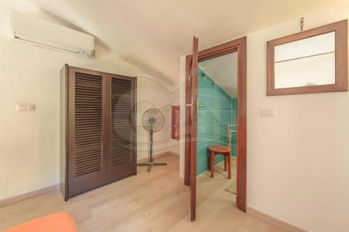 a room with a door and a chair and a table at Villa Marilena - Goelba in Fetovaia