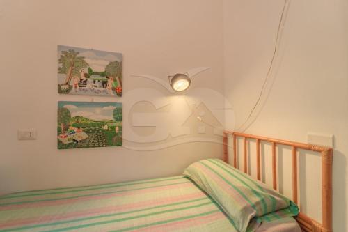 a bedroom with a crib and a painting on the wall at Villa Marilena - Goelba in Fetovaia
