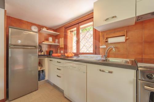 a kitchen with a sink and a refrigerator at Villa Marilena - Goelba in Fetovaia