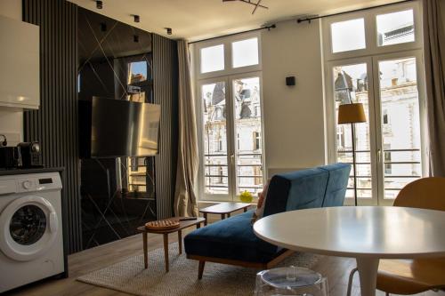 un salon avec un canapé bleu et une table dans l'établissement Suite Charles - 2 pers chic & intemporelle, à Charleville-Mézières