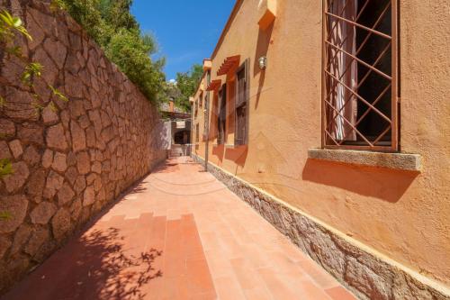 an alley with a building and a stone wall at Villa Marilena - Goelba in Fetovaia