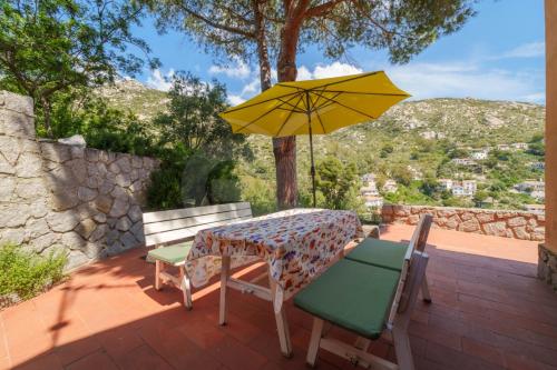 a table and two chairs with a yellow umbrella at Villa Marilena - Goelba in Fetovaia