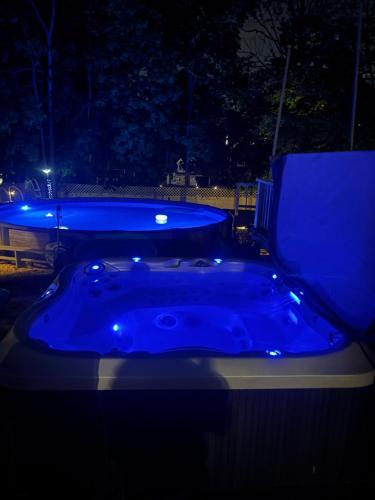 a blue jacuzzi tub in a yard at night at Bloom Victorian Bed & Breakfast in South Orange