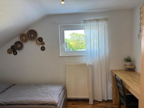 a bedroom with a bed and a window and a desk at Wohnzeit-Köln in Cologne