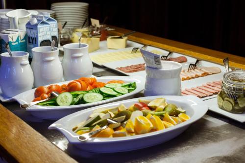 two plates of food on a table with vegetables at STF Wendelsberg Hotel & Hostel in Mölnlycke