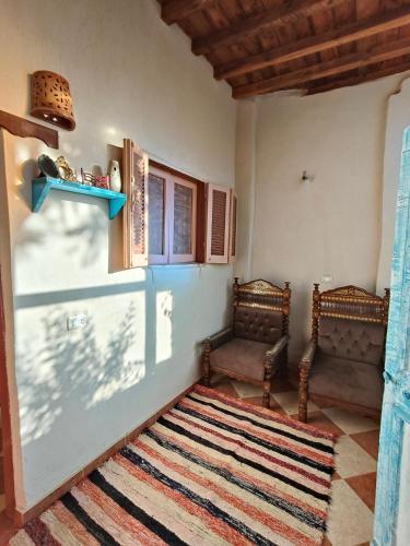 a living room with two chairs and a rug at Motel moon in Tunis