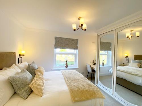 a bedroom with a large white bed and a desk at The Seaview Suites and Ground Floor Suite at The Corbyn Apartments in Torquay