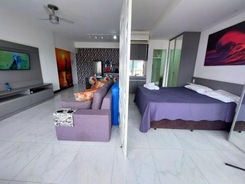 a bedroom with a bed and a couch in a room at Book Santos — Unlimited 1412 — Estúdio completo… in Santos
