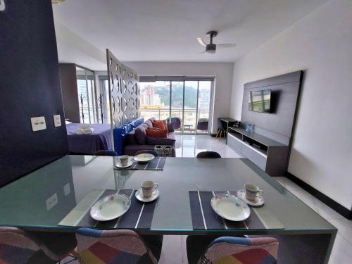 a living room with a table with cups and plates on it at Book Santos — Unlimited 1412 — Estúdio completo… in Santos