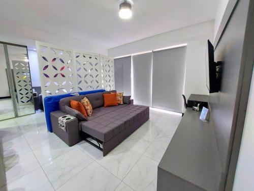 a living room with a couch and a tv at Book Santos — Unlimited 1412 — Estúdio completo… in Santos
