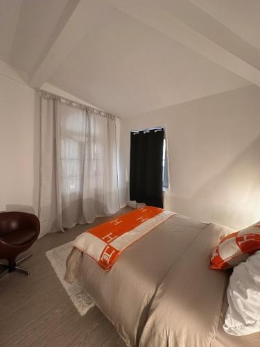 une chambre avec un lit, une chaise et une fenêtre dans l'établissement Quai de Seine Tour Eiffel Trocadéro, à Paris