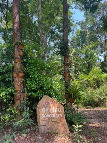 a sign in the middle of a forest with trees at Dugong Bay - Làng Ẩm Thực & Sinh Thái - Eco & Seafood Village in Phu Quoc