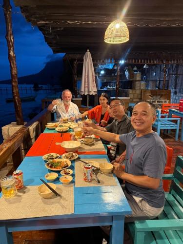 a group of people sitting at a table eating food at Dugong Bay - Làng Ẩm Thực & Sinh Thái - Eco & Seafood Village in Phu Quoc