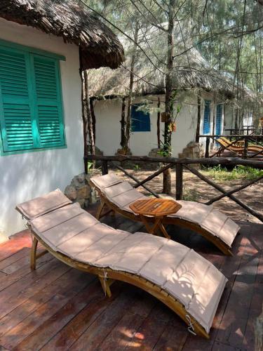 a wooden deck with a bench and a house at Dugong Bay - Làng Ẩm Thực & Sinh Thái - Eco & Seafood Village in Phu Quoc