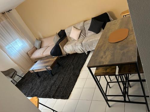 un salon avec un canapé et une table dans l'établissement Appartement deux chambres jardin parking, à Portet-sur-Garonne