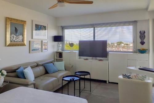 un salon avec un canapé et une télévision à écran plat dans l'établissement Charming studio - 2 pers close to Cannes, à Mandelieu-la-Napoule