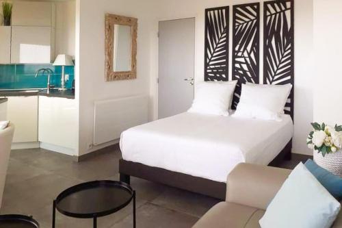 une chambre avec un lit blanc et un canapé dans l'établissement Charming studio - 2 pers close to Cannes, à Mandelieu-la-Napoule