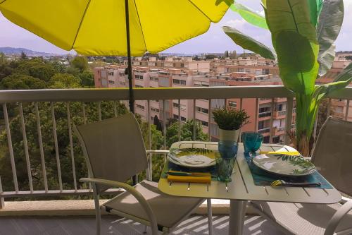 une table et des chaises sur un balcon avec un parasol dans l'établissement Charming studio - 2 pers close to Cannes, à Mandelieu-la-Napoule