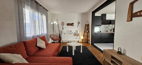 un salon avec un canapé rouge et une cuisine dans l'établissement Maison agréable, quartier calme, à Lorient