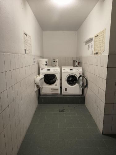 a laundry room with a washer and dryer in it at Harz-High-End-Ferienwohnung-Nicholas in Hahnenklee-Bockswiese